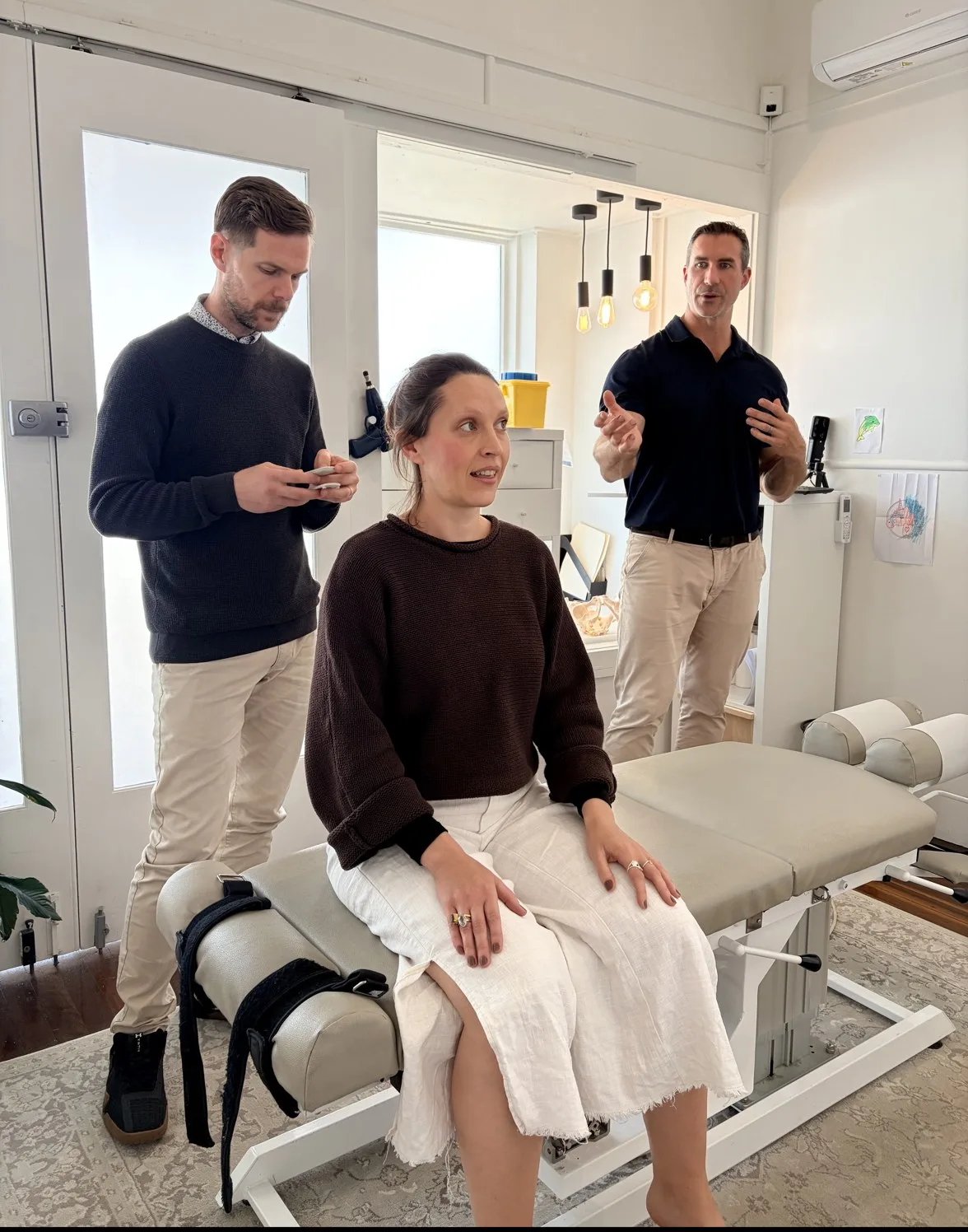 A patient being assessed by two chiropractors at Body & Soul Chiropractic