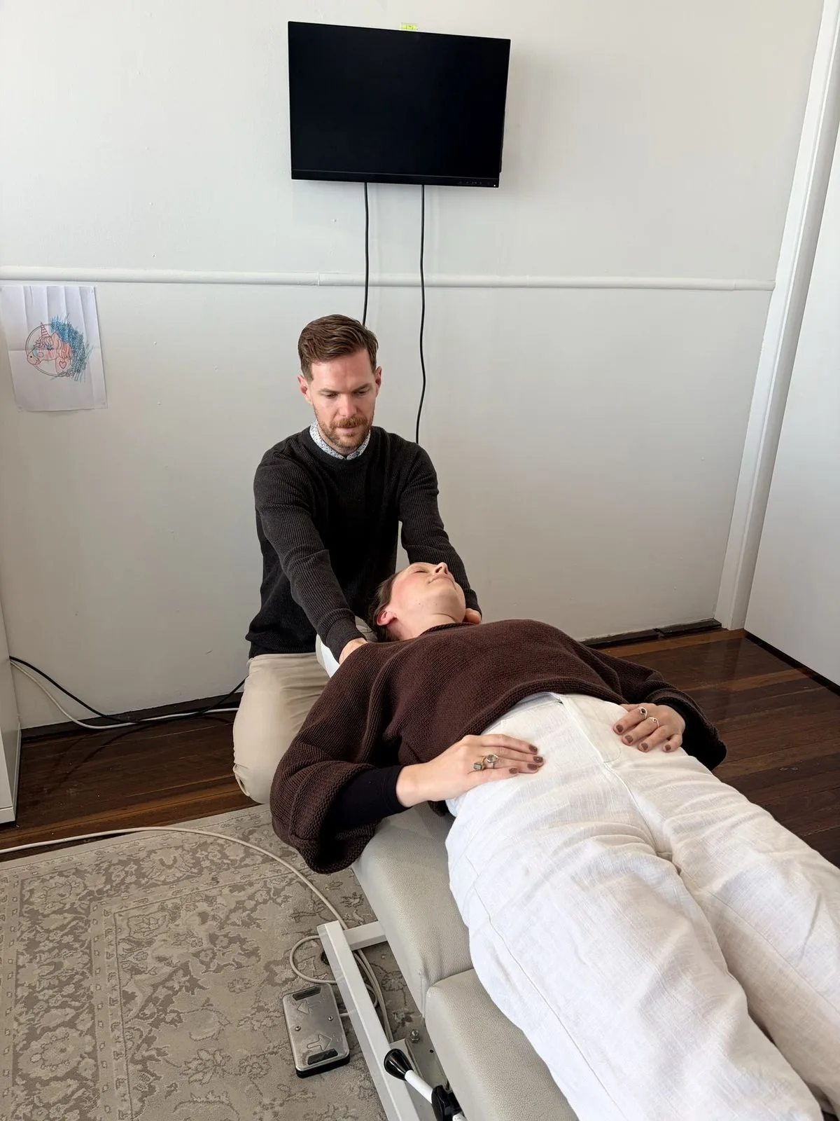 A chiropractor assessing a patient’s neck at Body & Soul Chiropractic